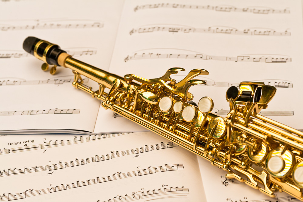 Close-up photo of a soprano saxophone and musical notes