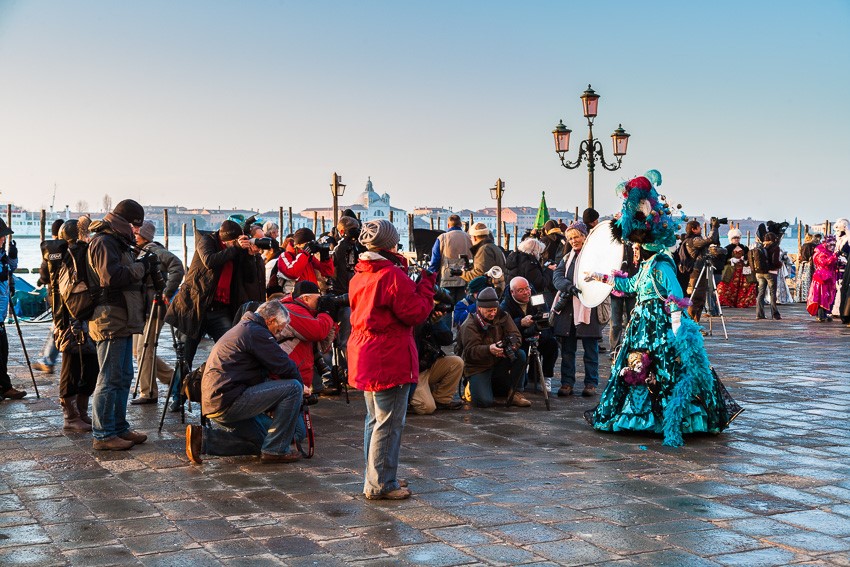 Photographers gathering around a costumed woman at the carnival in Venice, Italy