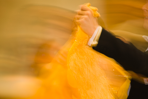 Abstract photo of a ballroom dancing couple where only their arms are sharp while the rest is blurred