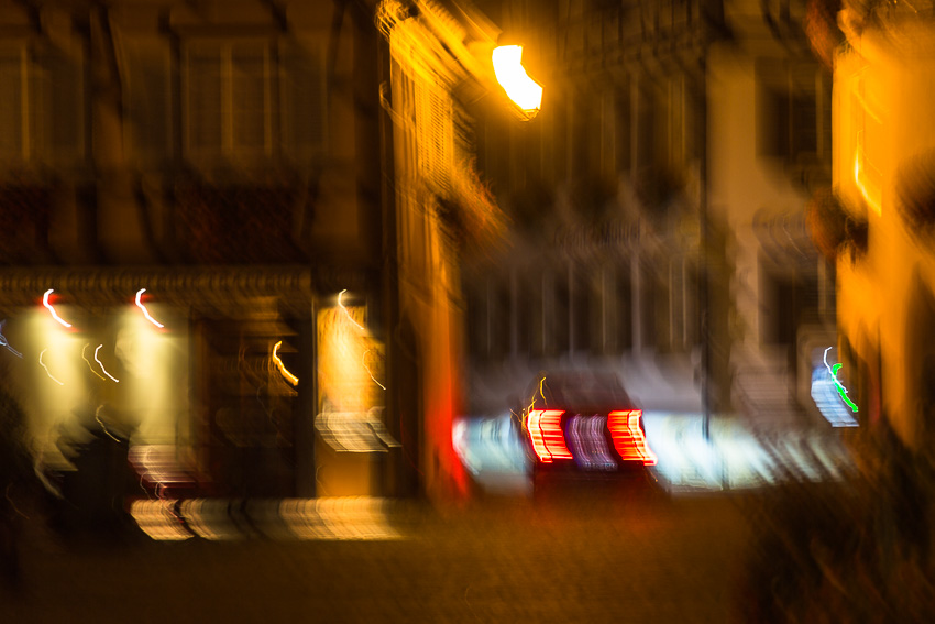 Blurred photo of a car driving through an alley at night