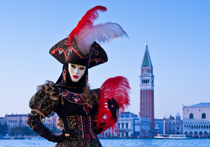 Photo of a masked person in front of the Campanile di San Marco, Venice, Italy